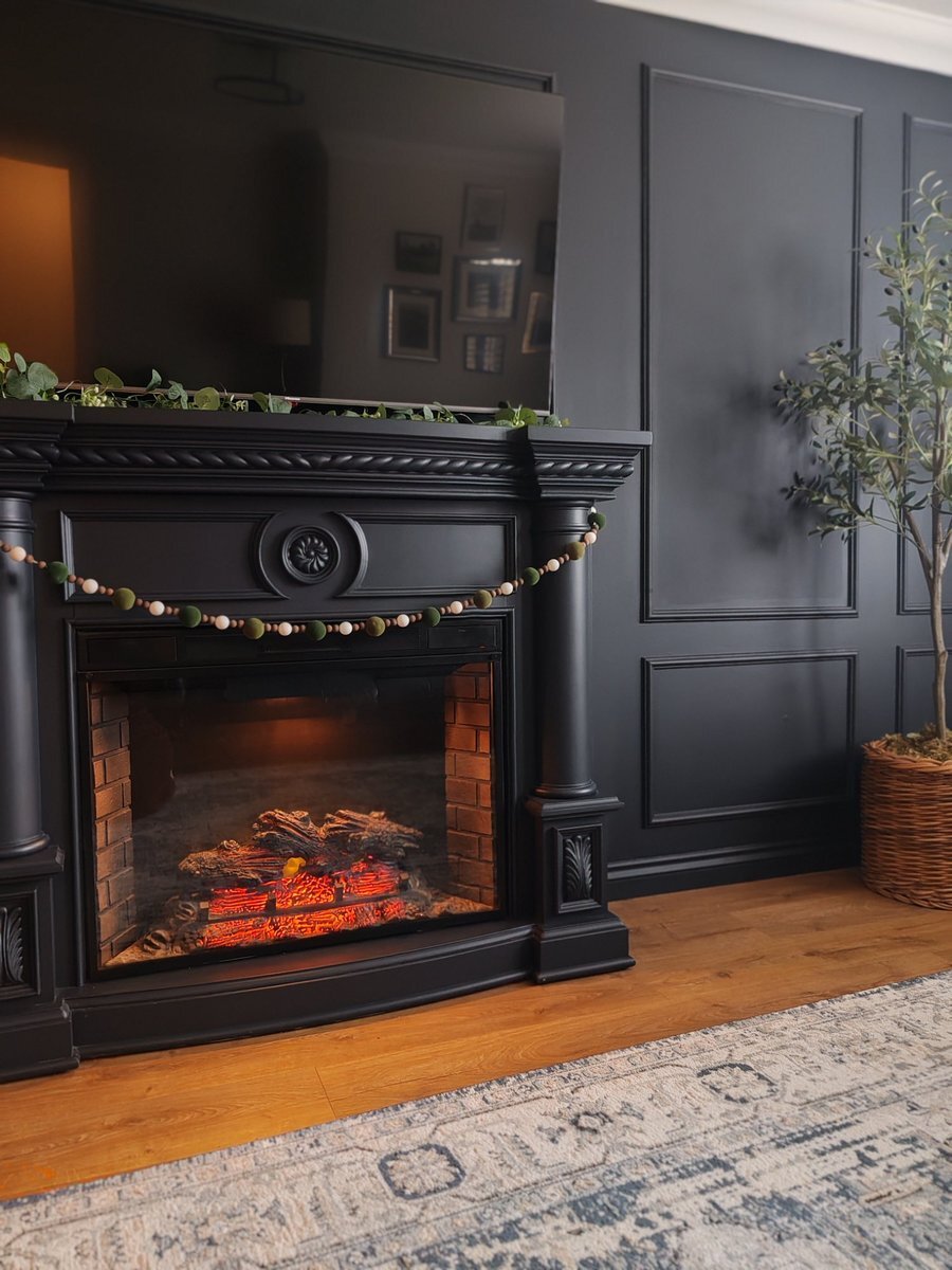 Dark wall panelling with black skirting board and electric fireplace feature wall