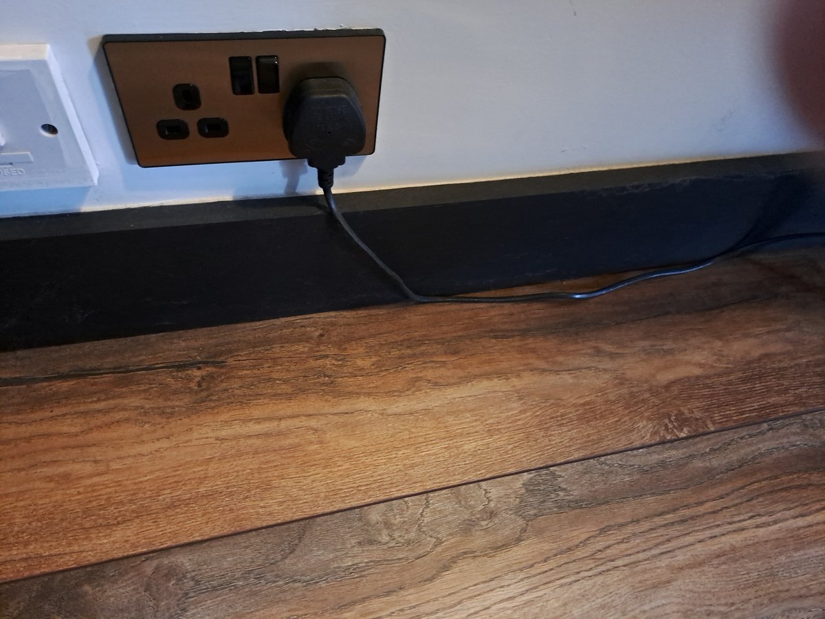 Black square edge skirting board with rustic wood effect flooring
