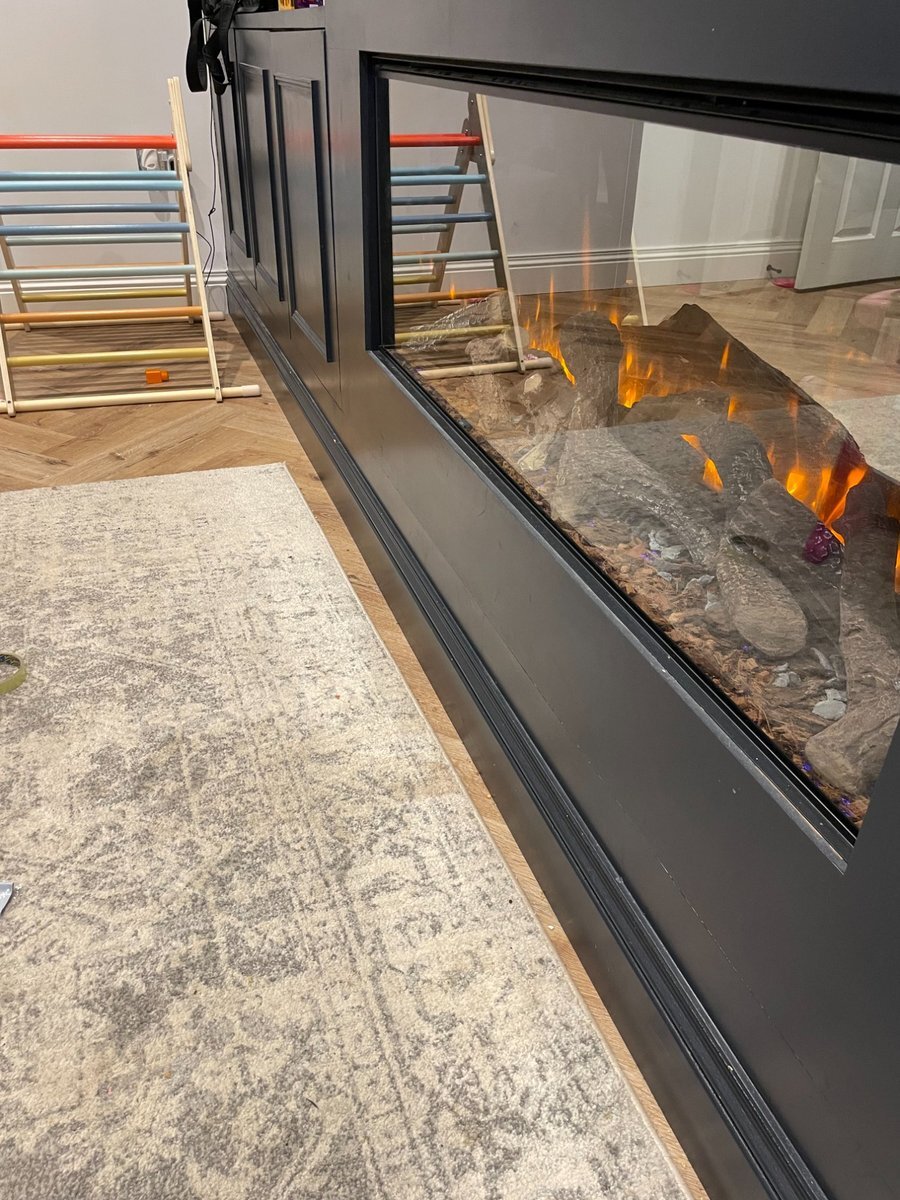 Dark skirting board with wall panelling fireplace surround in a living room