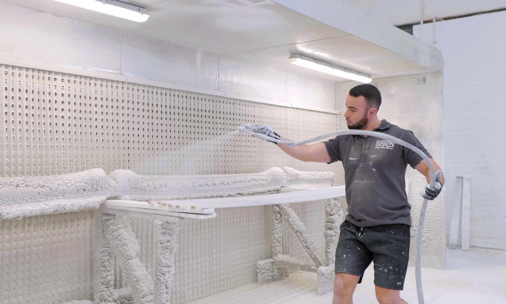 Automatic spray line applying primer to skirting boards