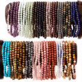 selection of 4 mm beaded stone bracelets on a wooden display shown on white background