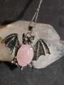 silver tone bat pendant with oval rose quartz stone, on a silver tone chain