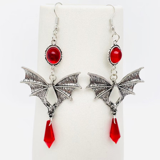 photo of pewter bat earrings with red crystal accents and french hooks on a white background