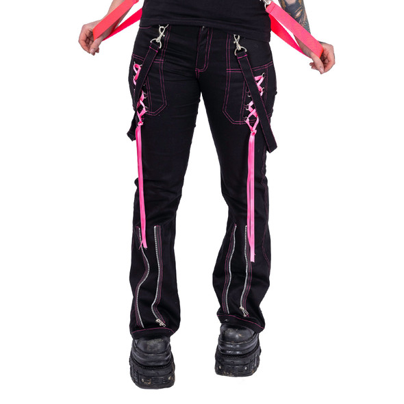 image of model from the waist down wearing black cargo pants with hot pink decorative straps and zippers on white background