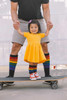 Cheerful toddler wearing bold rainbow socks with sneakers