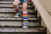 Kid in rainbow tube socks showing early pride and playfulness