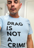 Close-up of a “Drag Is Not a Crime” t-shirt featuring bright, multicolored text on soft cotton fabric.