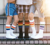 Child running freely in rainbow-striped socks, filled with energy and pride