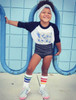 Kid sitting cross-legged in Pride Socks, happy and fearless