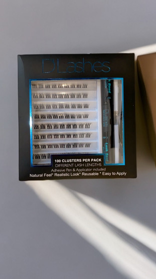 Introducing our latest addition to the D’Lashes family: the DIY Cluster Lashes Kit, designed for the ultimate lash experience in the comfort of your own home! With our kit, you’ll receive 100 cluster lashes in various sizes, ensuring a customizable fit for your unique eye shape and desired look.

But wait, there’s more! Each kit also includes our specially formulated seal and bond, ensuring that your lashes stay in place all day long. Plus, we’ve included our very own lash applicator for effortless application, making the process a breeze for everyone.

Whether you’re in between lash extension appointments or simply prefer the convenience of DIY lashes, our cluster lashes are perfect for you. Choose from a variety of styles to achieve your desired look, whether it’s natural and subtle or bold and glamorous.
