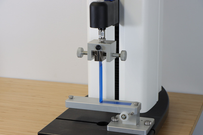 90° Peel Fixture measures the adhesive strength to pull a tape off of a rigid surface using force at a 90° angle.