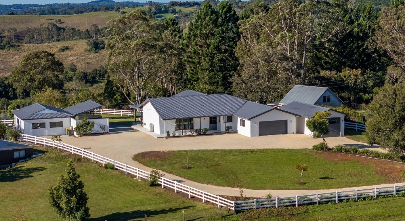 Acreage white PVC post and rail fence lifestyle photo.