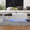 A coffee table with a glass top, storage drawers, and RGB LED lighting.
