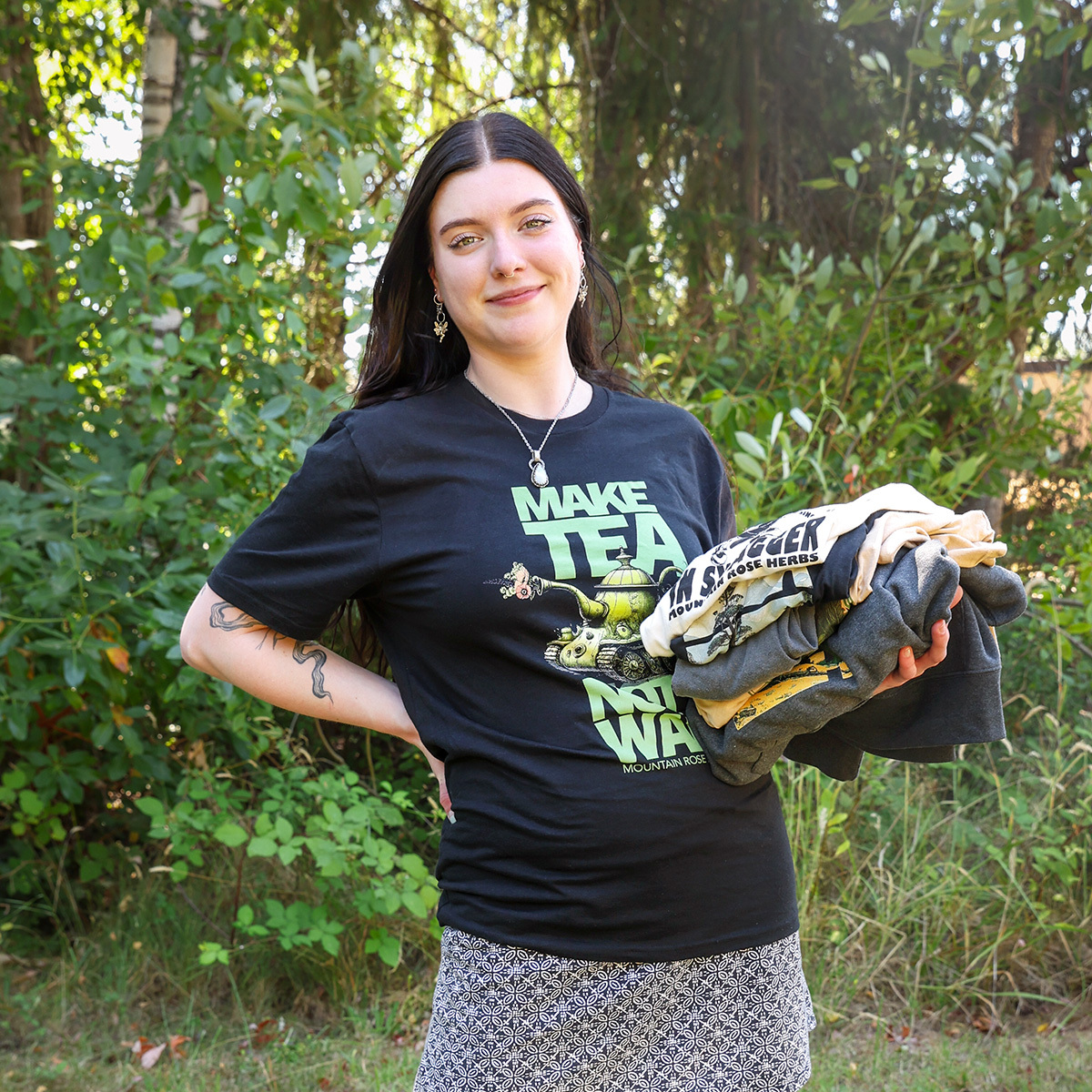 Person holding a stack of tshirts. 