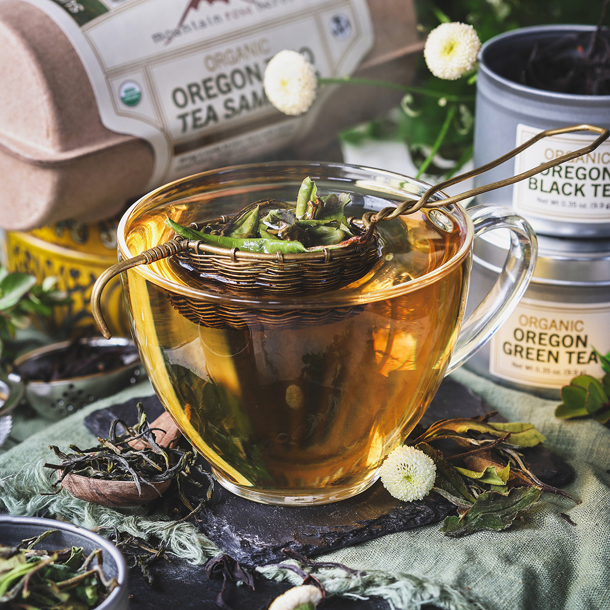 Tea brewing in cup with unfurled bright green tea leaves.