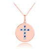 Cross disc pendant necklace with diamonds and sapphire in 14k rose gold.