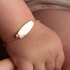 14K Yellow Gold Flower Nameplate Pearl Engravable Baby Bracelet on model