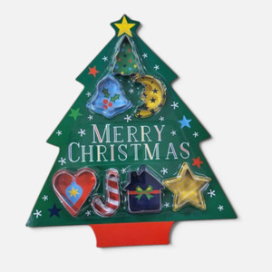 Artwrap Christmas Cookie Cutter Set 7 Piece displayed in green Christmas tree-shaped packaging, featuring festive cookie cutters including a tree, holly, star, candy cane, gift and ornaments.