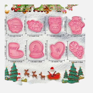 Christmas Cookie Embosser Cutter Set 8 Piece featuring pink plastic cutters with Santa, bells, reindeer, snowman, stocking, snow globe, mitten and candy cane designs.