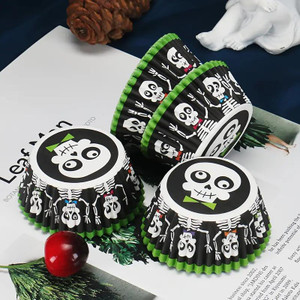 TM Cake Supplies Halloween Skeleton Cupcake Cases – 25 Pack, black and white skeleton design cupcake liners with green accents, displayed on a table with holiday decorations. TM Cake Supplies Halloween Skeleton Cupcake Cases – 25 Pack, black and white skeleton design cupcake liners with green accents, displayed on a table with holiday decorations.