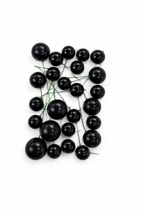 The Cake Mixer Midnight Black Ball Cake Decorations, wired mix, showing a set of shiny black spherical cake decorations with green wires inside a transparent container.