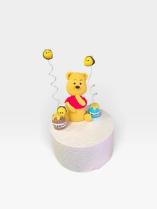 Handmade gumpaste Pooh cake topper with honey pots and bees, ideal for baby shower and first birthday cakes.