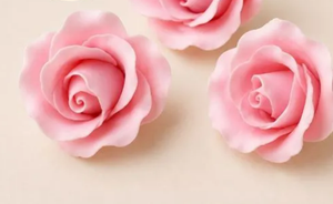 Handcrafted pink gumpaste rose cake decoration measuring approximately 4.5cm x 5cm, sold individually for wedding and celebration cakes.