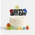 Lego-inspired Happy Birthday glitter cake topper with colourful building block decorations and smiling character face