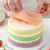 Silicone Layer Cake Pans 4 Inch - 4 Piece, colorful cake with multiple layers being assembled with a pink sponge layer on top.
