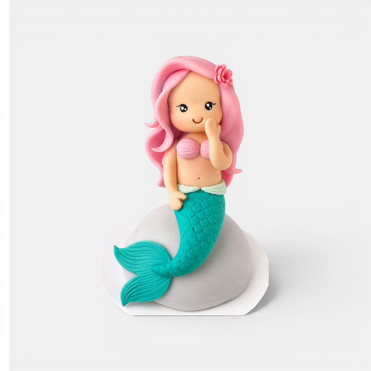 Handmade gumpaste mermaid cake topper with pink hair and turquoise tail for mermaid birthday cakes.