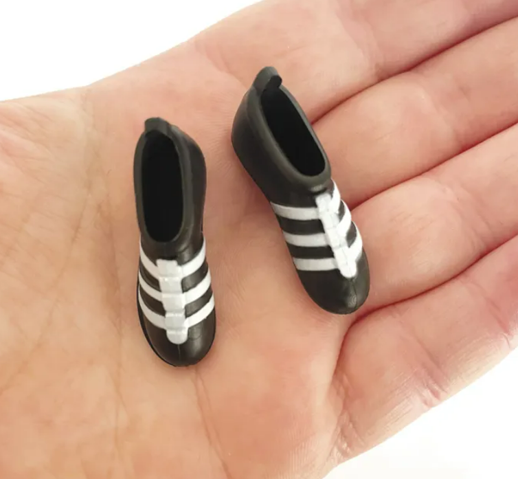Mini black and white soccer boots cake decorations measuring approximately 3cm x 1cm for football themed cakes