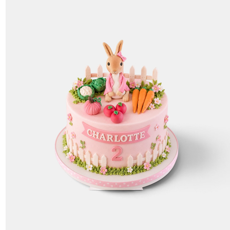 Deluxe Peter Rabbit cake in pink with handmade girl bunny, vegetable garden, flowers, fence and personalised name and age.
