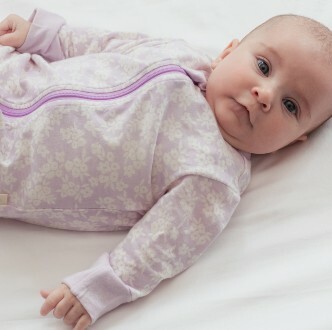 3-month-old-baby-lying-down-wearing-woolbabe-merino-and-organic-cotton-zipsuit-in-mauve-manuka-2.jpg