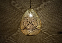 Handmade Moroccan brass pendant lamp, gold lantern chandelier fixture casting light patterns for kitchen, porch, or patio ceiling lighting.