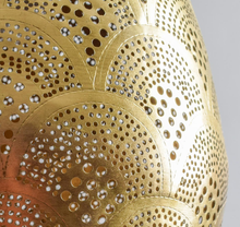 Hand-embossed teardrop brass pendant lamp with Moroccan detailing, casting decorative patterned shadows in any living space.