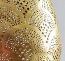 Hand-embossed teardrop brass pendant lamp with Moroccan detailing, casting decorative patterned shadows in any living space.