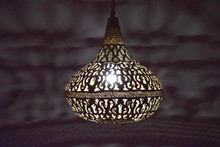 Boho Moroccan pendant lamp in durable brass, suspended from a chain to illuminate patios, porches, and outdoor living areas.