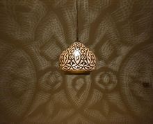 Moroccan dome pendant light fixture designed for bedrooms or cozy living spaces, casting patterned shadows with boho flair.