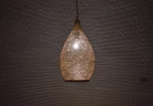 Handmade Moroccan brass pendant lighting fixture designed for kitchen islands, casting patterned glow as elegant hanging lights over dining and cooking areas.
