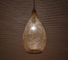 Brass Moroccan pendant lamp suspended over kitchen island, providing warm golden illumination and stylish ceiling accent.