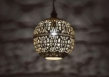 Boho Moroccan kitchen island pendent light with detailed hand-cut patterns, creating decorative shadows and cozy glow.