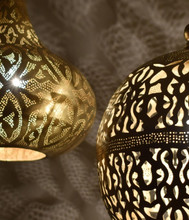 Hand-pierced Moroccan brass pendant lights above dining table