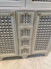 Carved bathroom vanity cabinet — rope-carved trim and lattice drawer fronts