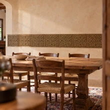 Tudor Rose hand-embossed solid brass tiles in aged bronze as a wainscot band in a dining room