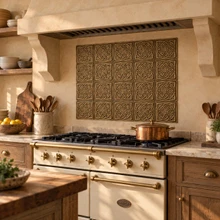 Woven Star Circle Knot in hand-embossed brass, as a backsplash panel behind a cream range under a plaster hood