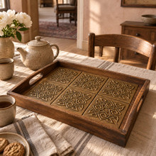 Diamond Lattice Knot Celtic knot tiles in hand-embossed brass, inlaid in the base of a wooden serving tray on a dining table
