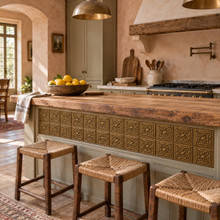 Star Cross Knot Celtic knot tiles in hand-embossed brass, set into the front panel of a kitchen island with rush stools