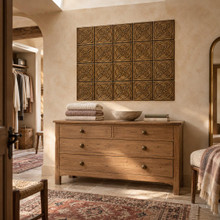 Quatrefoil Circle Knot in hand-embossed brass, as a wall panel above a wooden chest of drawers in a dressing room