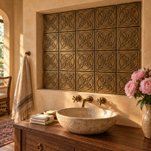Quatrefoil Circle Knot in hand-embossed brass, lining a plastered niche above a stone basin vanity in a bathroom