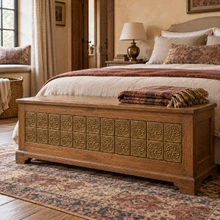 Woven Star Knot Celtic knot tiles in hand-embossed brass, inlaid in the front of a wooden blanket chest at a bed's foot